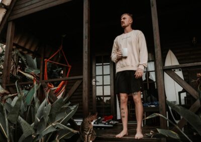 Guest on the deck of an A-frame bungalow at Umzumbe Surf Camp