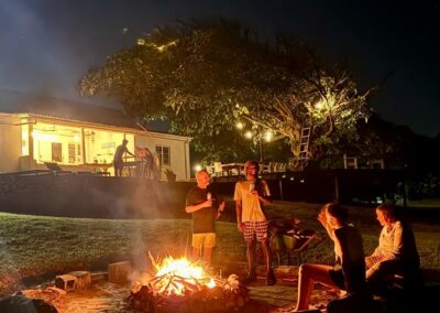 Guests around a bonfire at night at Umzumbe Surf Camp