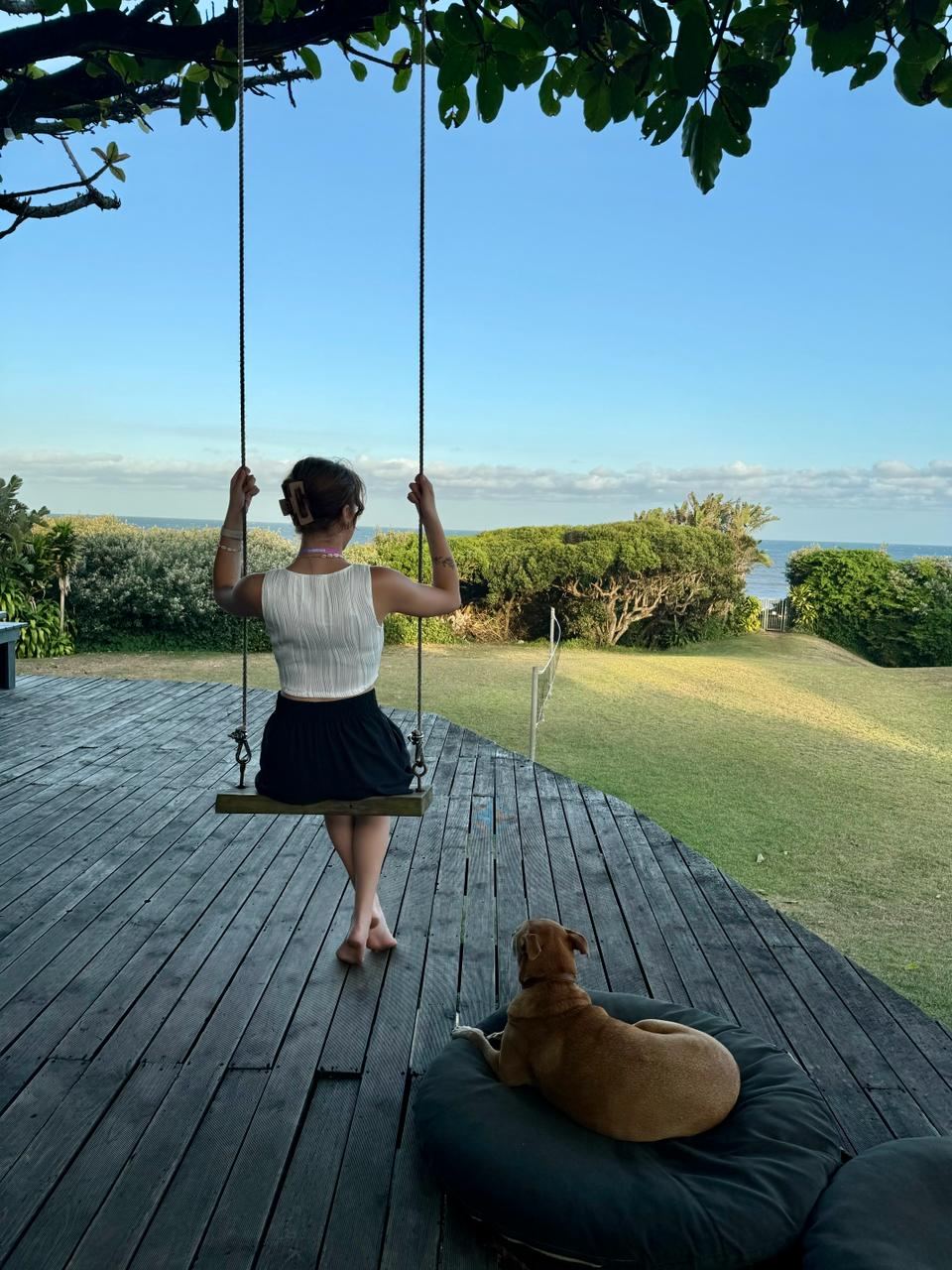 Dog by the deck swing with ocean views at Umzumbe Surf Camp