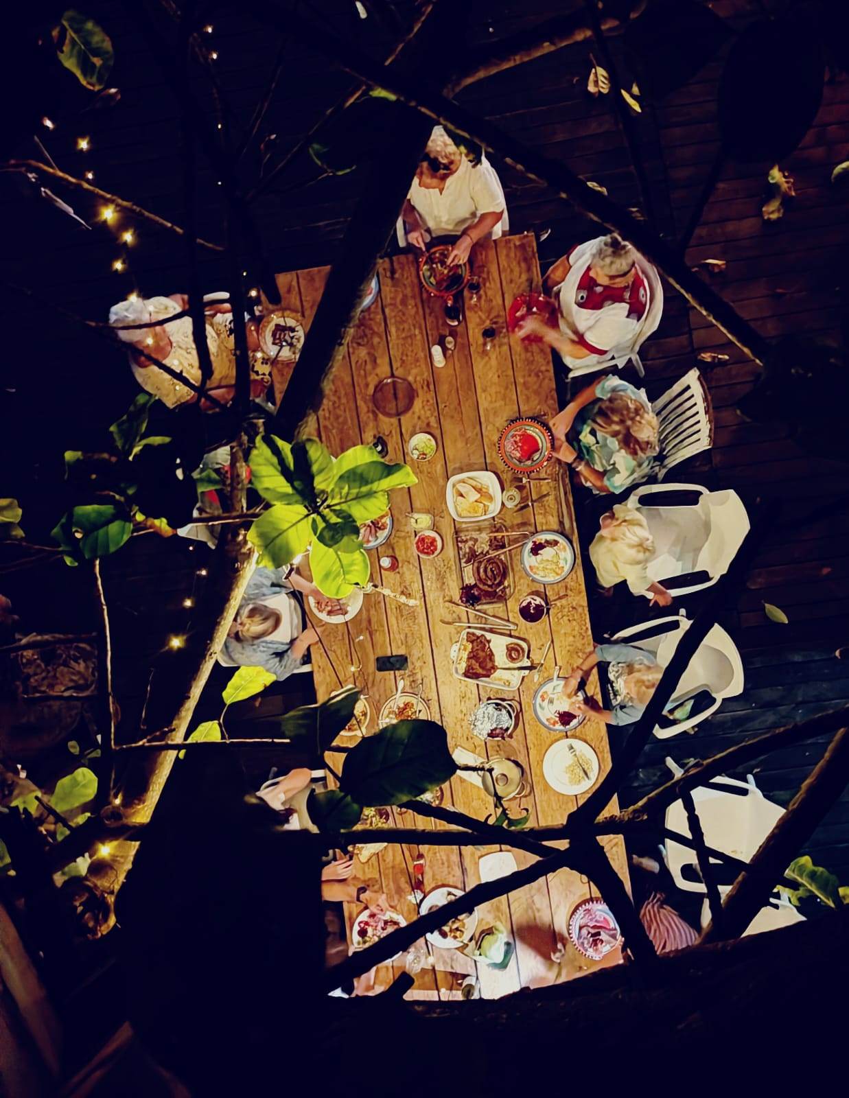 Overhead view of a dinner table at night, Umzumbe Surf Camp