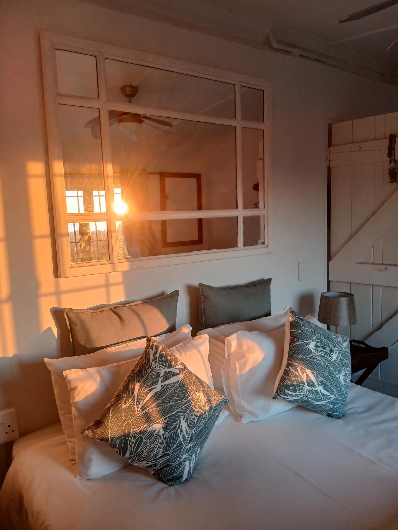 Bedroom in warm sunset light at Umzumbe Surf Camp