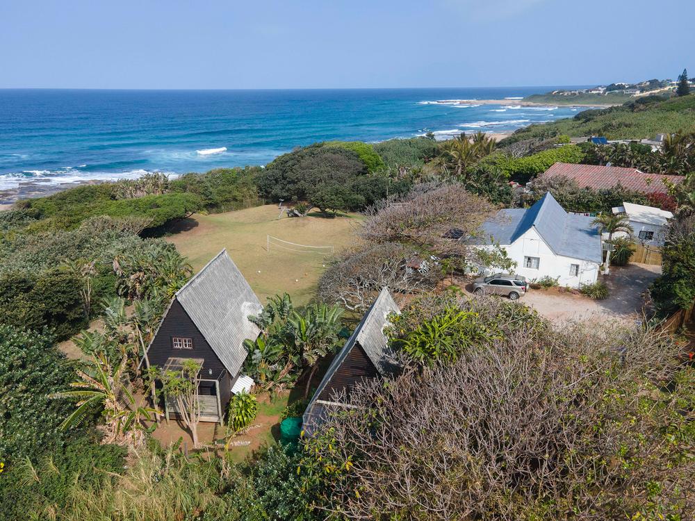 Aerial view of the A-frame bungalows and Surf House at Umzumbe Surf Camp