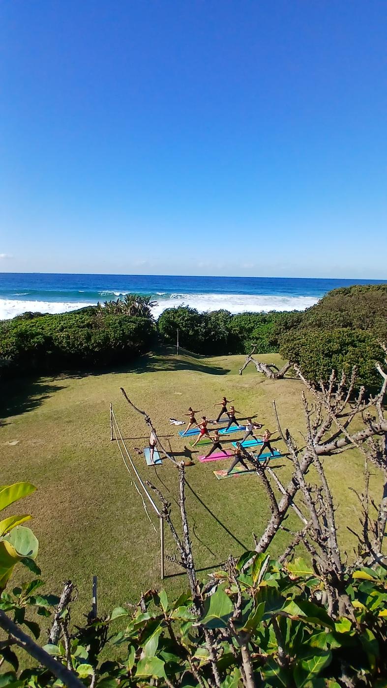 Yoga on the lawn with ocean views at Umzumbe Surf Camp